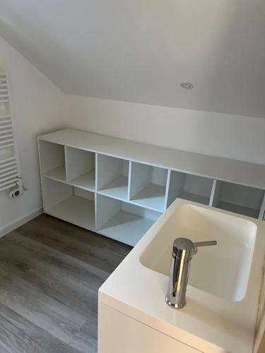 a white kitchen with a sink and a shelf at Le Sailhet, maison de vacances in Pierrefitte-Nestalas