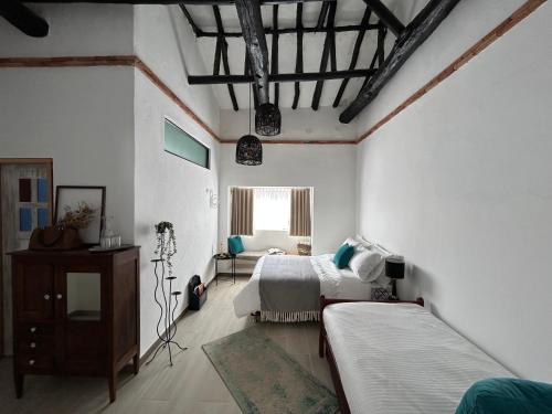 a bedroom with two beds and a window at Casa el Secreto in Tibasosa