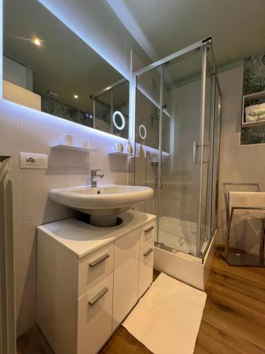 a white bathroom with a sink and a shower at Residenza San Rocco ''Suite sul lago'' in Orta San Giulio
