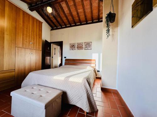 Un dormitorio con una cama y un taburete. en Casina del Fabbro, en Montescudaio