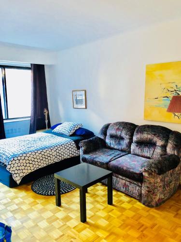 a living room with a couch and a bed at Stylish Montreal Apartment: Comfortable Stay in the Golden Square Mile in Montreal