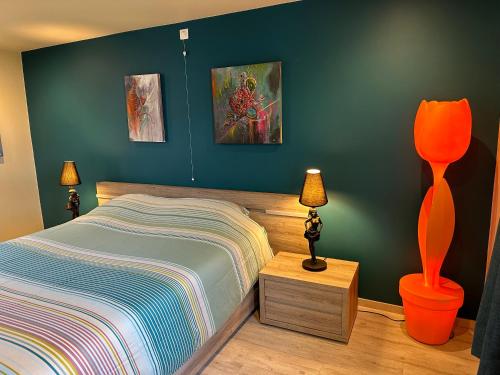 a bedroom with a bed and a blue wall at Unieke Wellness Boerderij - Vlaamse Ardennen in Zottegem