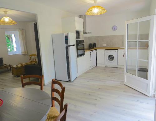 Il comprend une cuisine équipée d'un réfrigérateur, d'une table et de chaises. dans l'établissement LES BOULEGONS au pied du LUBERON, à Lourmarin