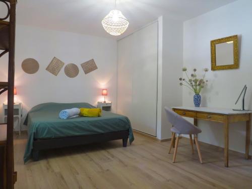 une chambre avec un lit, un bureau et une table dans l'établissement LES BOULEGONS au pied du LUBERON, à Lourmarin