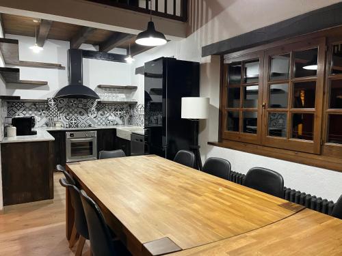 a large kitchen with a wooden table and chairs at Cabanya les Moreres in Molló