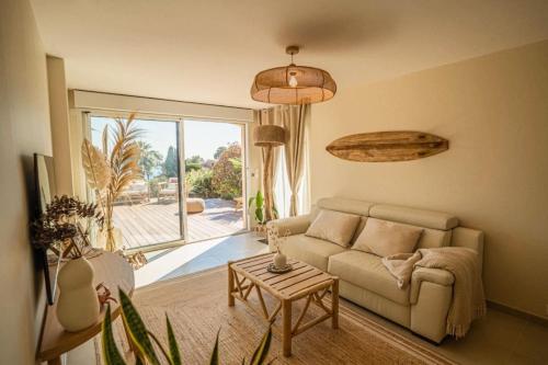 a living room with a couch and a table at Logement vue mer splendide - situé à 50 mètres du bord de mer et 2 minutes des plages - Bandolina in Bandol