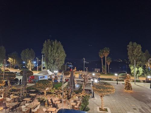 a park with tables and chairs at night at Seaview-Apartments in Palaia Fokaia