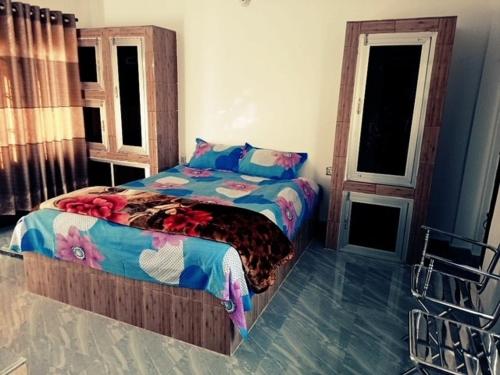 a bedroom with a bed and two windows at Juri Cottage: Duplex style, Sylhet divison, Bangladesh 