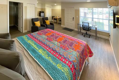 a bedroom with a bed with a colorful blanket on it at Summerwind Studios in Fort Myers