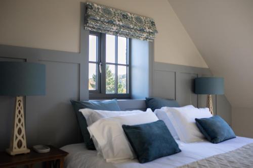 a bedroom with a bed with blue and white pillows at Lakeview Barn, sleeps 5-7 Guests new inside in Matlock