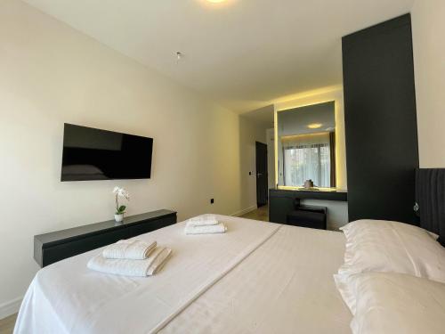 a bedroom with a bed with two towels on it at Botanica Boutique Hotel in Ulcinj