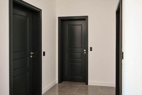 two black doors in a room with white walls at Botanica Boutique Hotel in Ulcinj