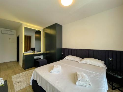 a bedroom with a bed with two towels on it at Botanica Boutique Hotel in Ulcinj