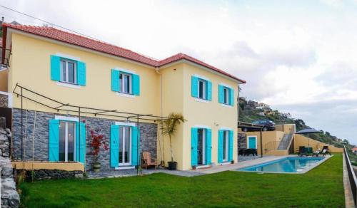 Casa con persianas azules y piscina en Villa Pargo, en Fajã da Ovelha