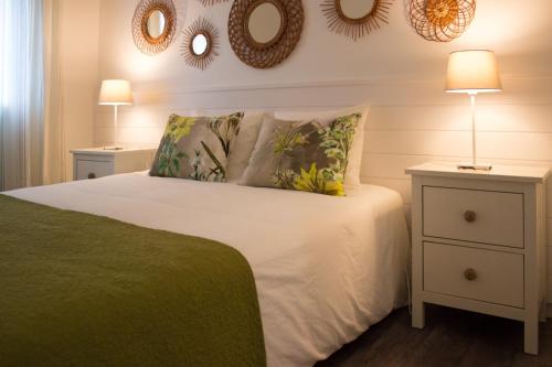 Un dormitorio con una cama y dos espejos en la pared. en Villa Pargo, en Fajã da Ovelha