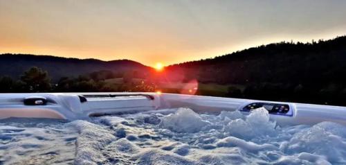 een truck bedekt met sneeuw met de zonsondergang op de achtergrond bij New cabin with jacuzzi, sauna and ski inout in Svingvoll