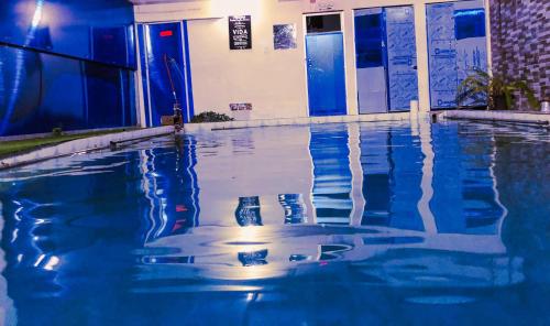 una piscina con acqua blu di fronte a un edificio di Hospedaje Familiar Valentina a Mera