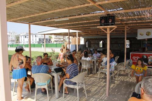 a group of people sitting at tables in a restaurant at Sunset Village in Didim