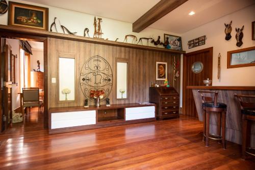 a living room with wood paneling and a table at Pousada Déllis in Visconde De Maua