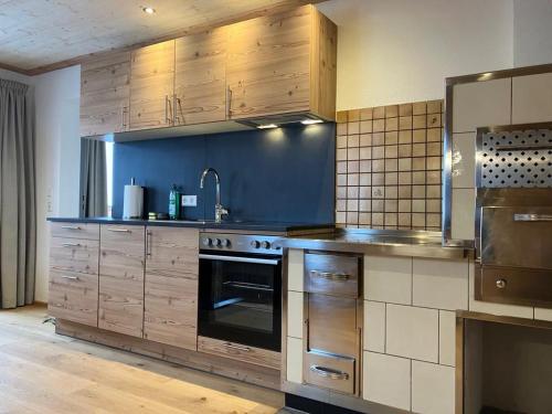 cocina grande con armarios de madera y horno en Apartment Obergruberhof, en Schladming