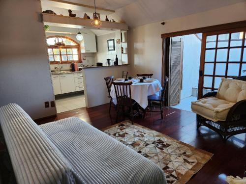 een woonkamer met een tafel en een keuken bij Apartamento a 150m da Rua Coberta in Gramado