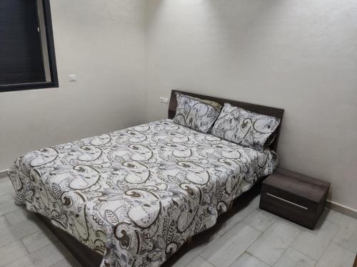 a bedroom with a bed and a night stand at Nice appa in Kenitra