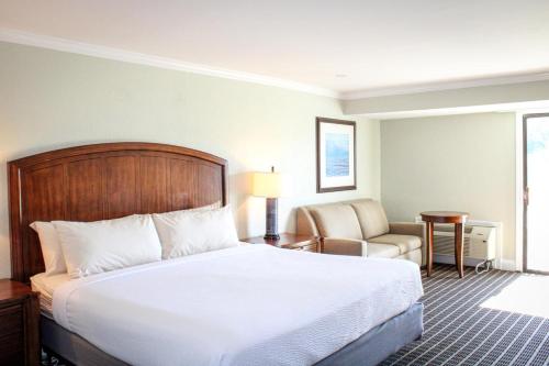 a hotel room with a bed and a chair at Cape Cod Irish Village - The Emerald Resort in Barnstable