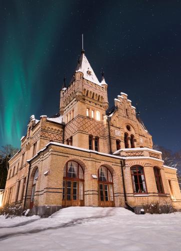 an old building in the snow with a green sky at Merlo Slott in Timrå