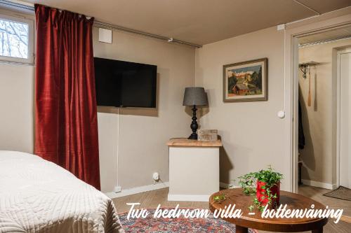 a bedroom with a bed and a television on the wall at Merlo Slott in Timrå