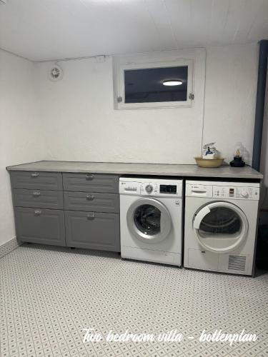 a laundry room with a washer and dryer in it at Merlo Slott in Timrå