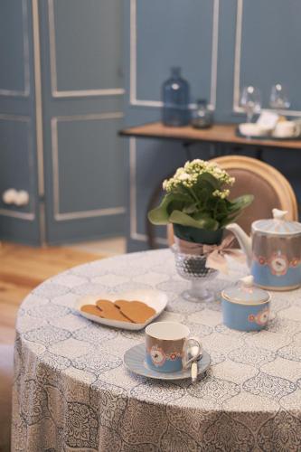 a table with a plate of cookies and a cup of coffee at La Cles Deluxe Suites in Cles