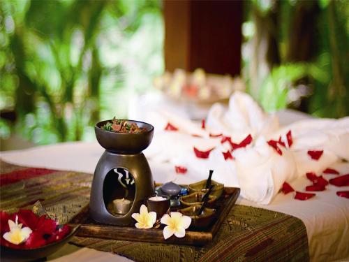 a tray with a vase and some flowers on a table at Mangrove Tree Resort World Sanya Bay-Kapok in Sanya