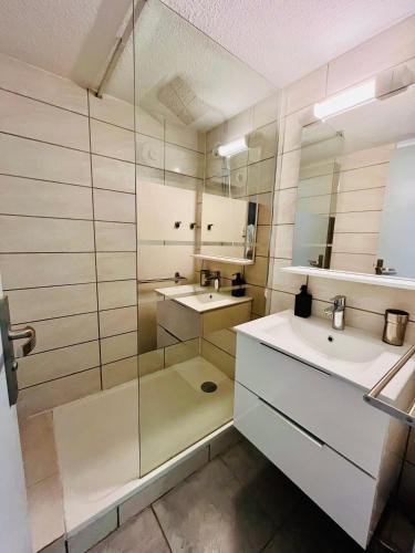 une salle de bain avec deux lavabos et une douche en verre dans l'établissement Le Scarlett - Piscine, parking et proche plage, à Palavas-les-Flots