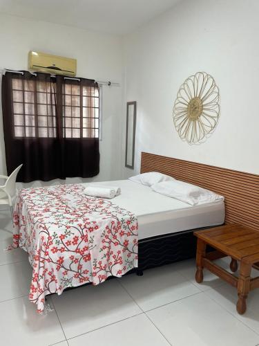 um quarto com uma cama com um cobertor vermelho e branco em Pousada hostel praia itapua em Salvador