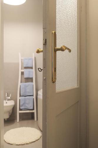 a door to a bathroom with a toilet and a sink at La Cles Deluxe Suites in Cles