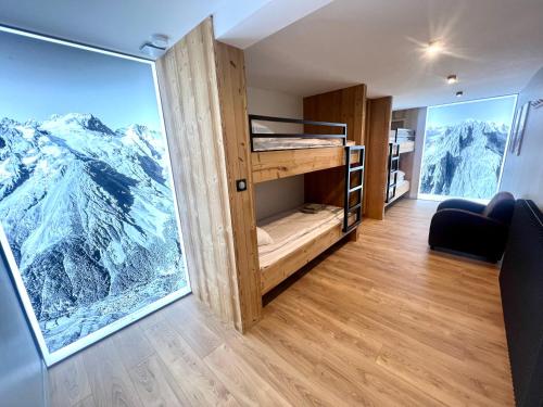 a room with bunk beds with a view of mountains at Appartements Chalet Lauranoure Centre Station in Les Deux Alpes