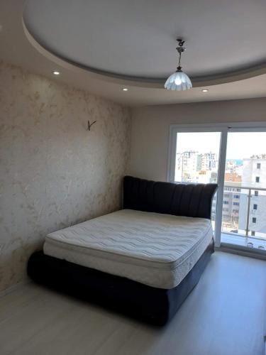 een slaapkamer met een bed in een kamer met een raam bij شقة عائلية في ريف اسطنبول in Arnavutköy