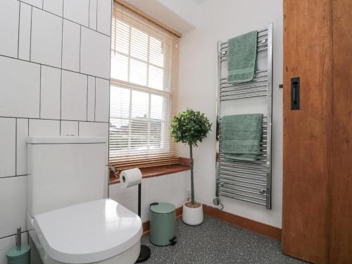 a bathroom with a toilet and a window at Bay Tree Cottage in Pickering