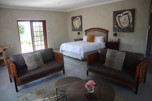 a bedroom with a bed and two chairs and a table at The Meander Estate in Balmoral