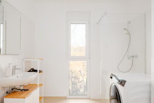 a bathroom with a sink and a washing machine at Oidahome - Apartment am Hauptbahnhof - contactless Self-Check-IN in Graz