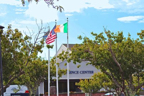 two flags on poles in front of a building at Cape Cod Irish Village - The Emerald Resort in Barnstable