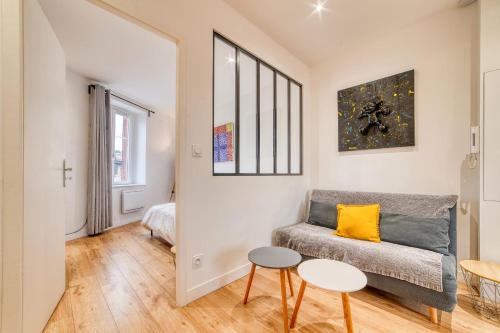 un salon avec un canapé et deux tables dans l'établissement Le Victor Hugo - T2 cosy Horloge-Tassin, à Tassin-la-Demi-Lune