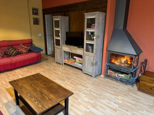 a living room with a fireplace and a red couch at Ca la Bet in Claravalls