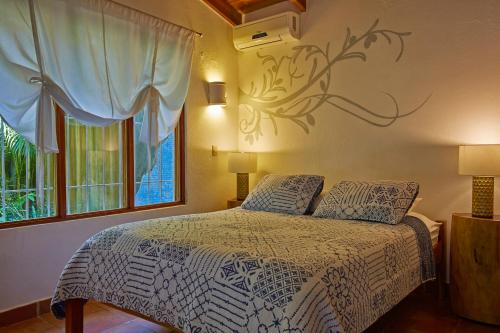 1 dormitorio con cama y ventana en Living Hotel, en Nosara