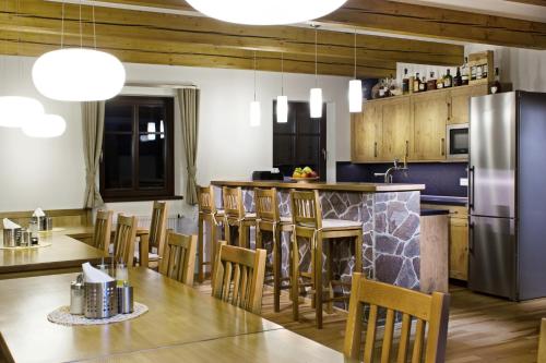 a kitchen with a table and chairs and a refrigerator at Penzion Na Začátku in Benecko