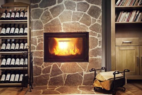 a stone fireplace in a room with wine bottles at Penzion Na Začátku in Benecko