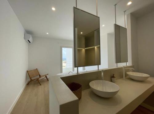 La salle de bains est pourvue de 2 lavabos et d'un grand miroir. dans l'établissement Villa Islander, à Cala Morell