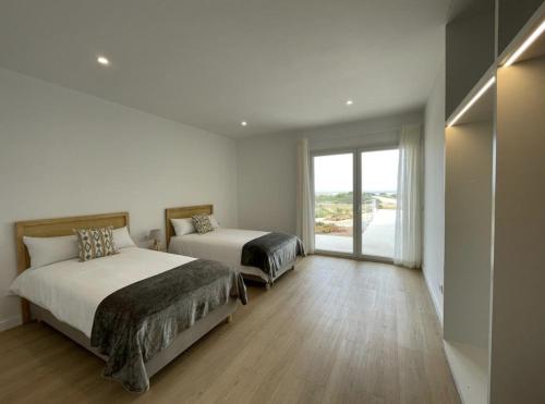 - une chambre avec 2 lits et une grande fenêtre dans l'établissement Villa Islander, à Cala Morell