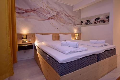 a bedroom with a large bed with white sheets at Ambiente by Next Inn in Hamburg