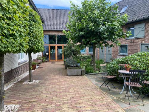 a brick courtyard with a table and chairs and a tree at Dalauro Next Bed & Breakfast in Eys